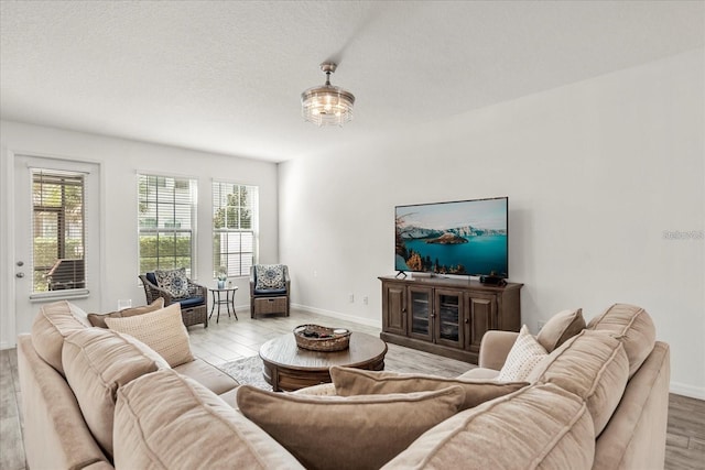 2710 Bolzano Dr, Apopka, FL 32712 - living room featuring light wood-style flooring, a textured ceiling, and baseboards