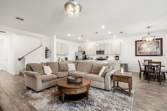 2710 Bolzano Dr, Apopka, FL 32712 - living room featuring light wood-style floors, visible vents, recessed lighting, stairway, and baseboards