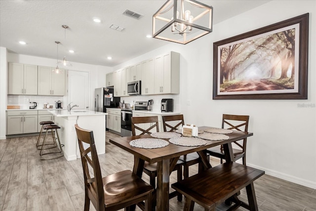 2710 Bolzano Dr, Apopka, FL 32712 - dining space featuring light wood-type flooring, baseboards, a chandelier, recessed lighting, and visible vents