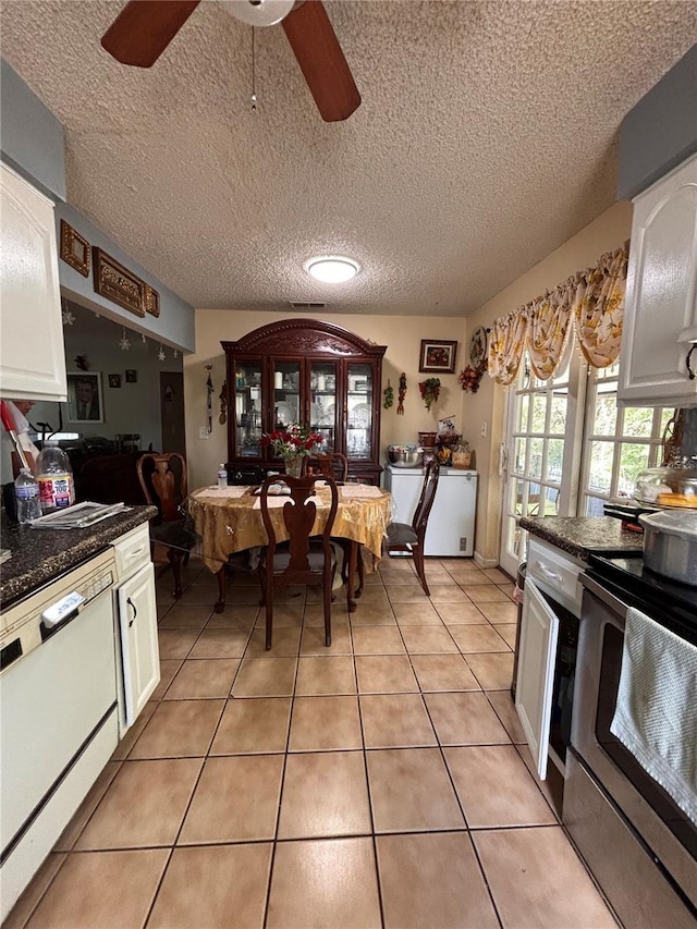 3219 Chariot Pl, Orlando, FL 32818 - kitchen featuring stainless steel electric range oven, white dishwasher, ceiling fan, dark countertops, and white cabinetry