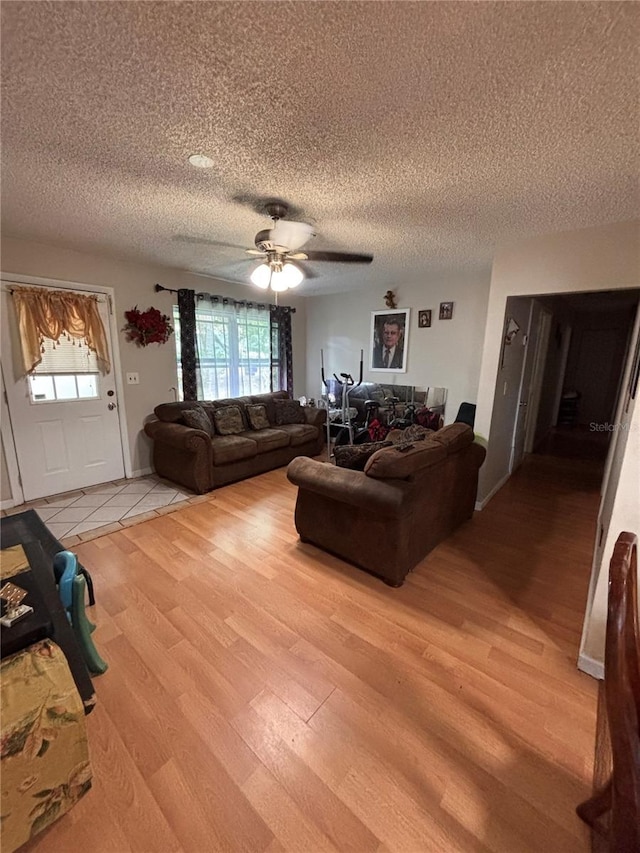 3219 Chariot Pl, Orlando, FL 32818 - living area featuring light wood-style floors, ceiling fan, a textured ceiling, and a healthy amount of sunlight
