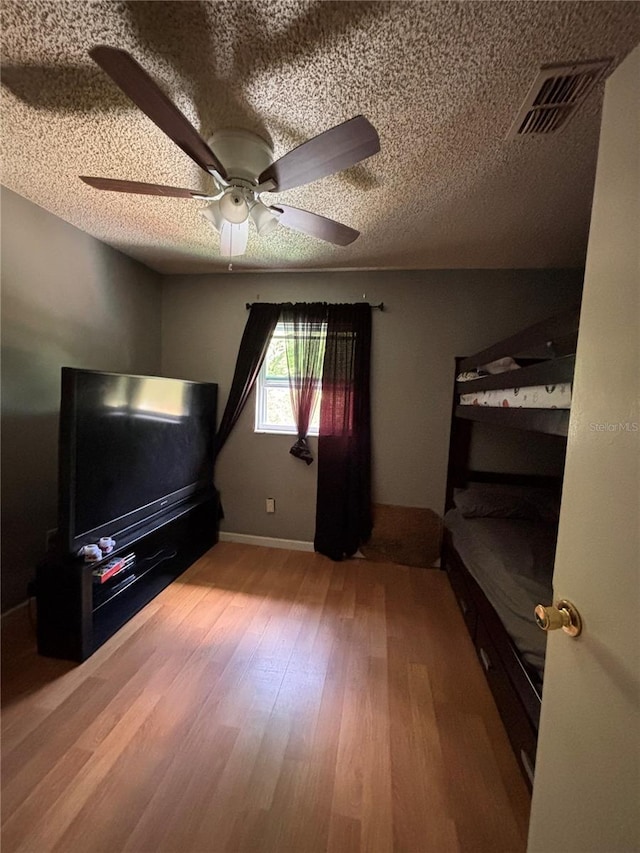 3219 Chariot Pl, Orlando, FL 32818 - bedroom featuring visible vents, a textured ceiling, a ceiling fan, and wood finished floors