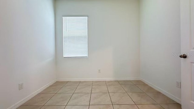 unfurnished room featuring baseboards and light tile patterned flooring