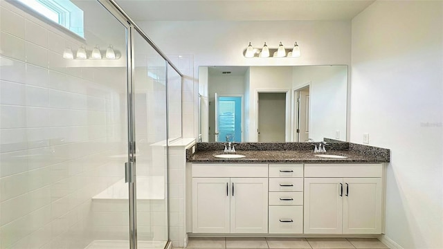 full bathroom featuring double vanity, a sink, and a stall shower