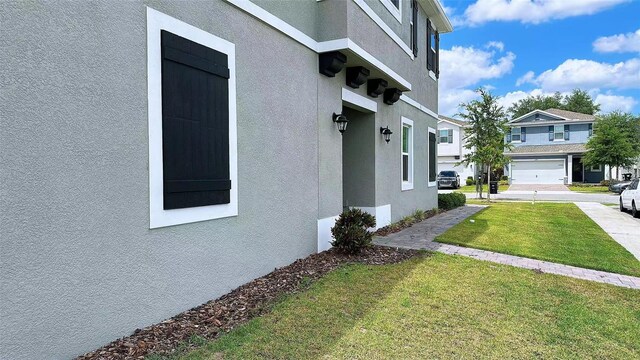 view of home's exterior featuring a residential view, a lawn, and stucco siding