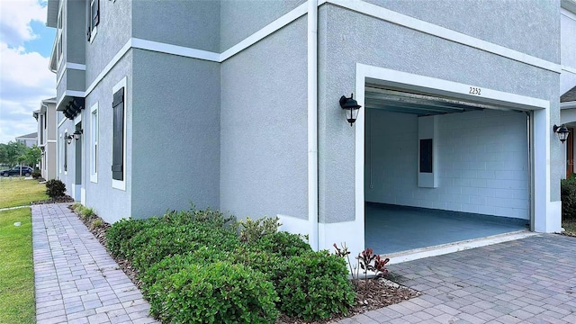 view of property exterior featuring stucco siding and decorative driveway