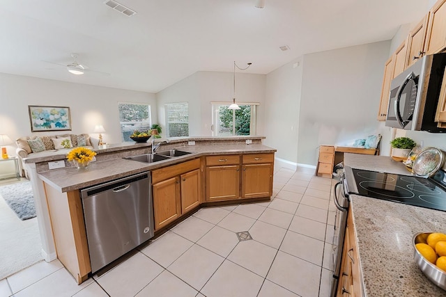 kitchen with a sink, stainless steel appliances, pendant lighting, open floor plan, and visible vents