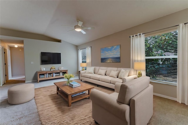living area featuring baseboards, ceiling fan, light colored carpet, and vaulted ceiling