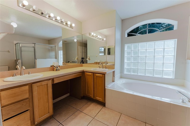 bathroom featuring a garden tub, tile patterned flooring, a shower stall, and a sink