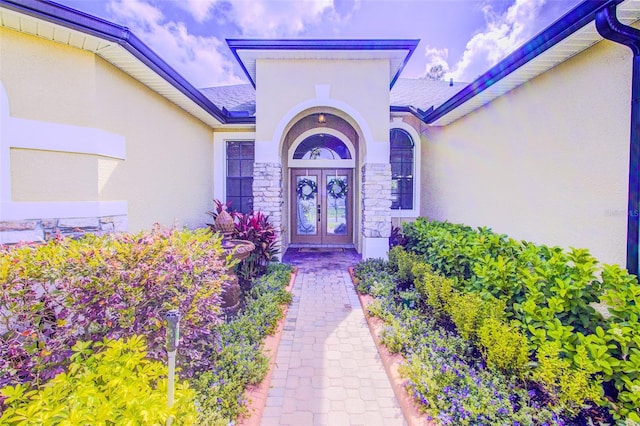 2626 Greenwillow Dr, Orlando, FL 32825 - view of exterior entry with french doors, stucco siding, stone siding, and a shingled roof