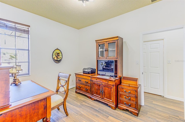 2626 Greenwillow Dr, Orlando, FL 32825 - office area with light wood-style floors, baseboards, and a textured ceiling
