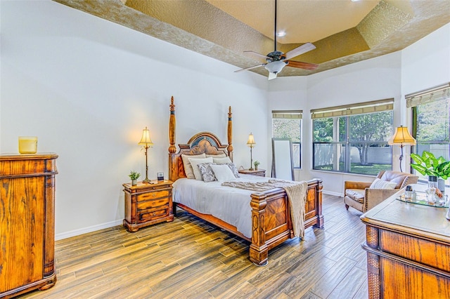 2626 Greenwillow Dr, Orlando, FL 32825 - bedroom with baseboards, wood finished floors, a high ceiling, a tray ceiling, and recessed lighting