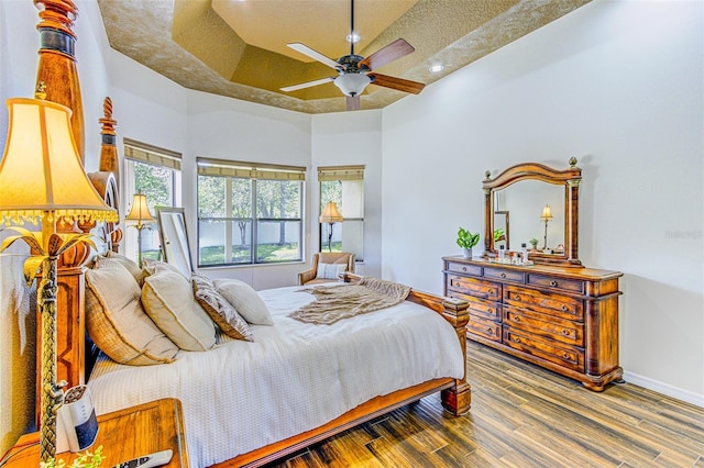 2626 Greenwillow Dr, Orlando, FL 32825 - bedroom featuring a raised ceiling, wood finished floors, baseboards, ceiling fan, and recessed lighting