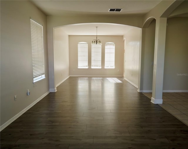 13520 Meadow Bay Loop, Orlando, FL 32824 - unfurnished dining area featuring baseboards, arched walkways, visible vents, and dark wood finished floors