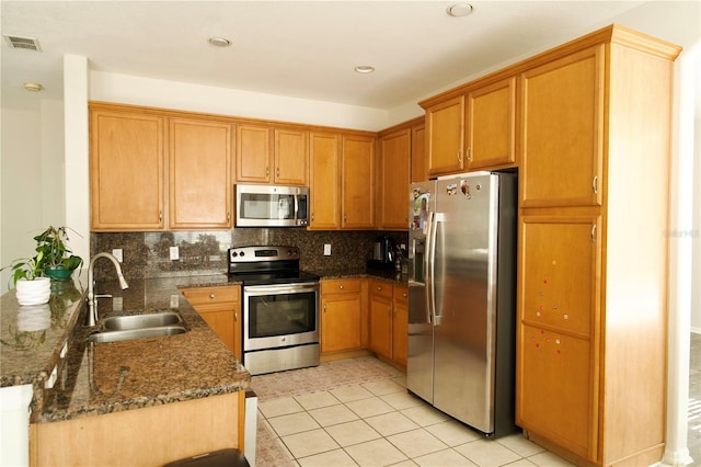 13520 Meadow Bay Loop, Orlando, FL 32824 - kitchen with visible vents, a peninsula, appliances with stainless steel finishes, a sink, and backsplash