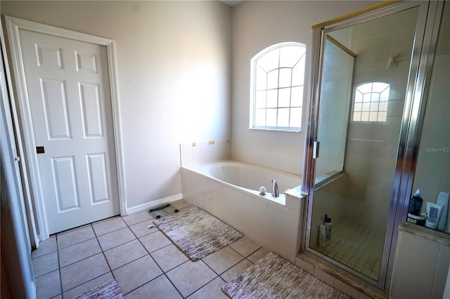 13520 Meadow Bay Loop, Orlando, FL 32824 - full bathroom featuring a shower stall, tile patterned floors, baseboards, and a bath