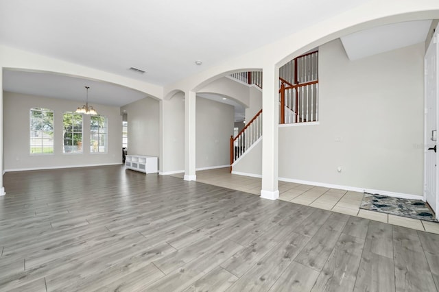 13520 Meadow Bay Loop, Orlando, FL 32824 - unfurnished living room with wood finished floors, a chandelier, and stairs
