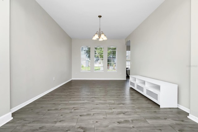 13520 Meadow Bay Loop, Orlando, FL 32824 - unfurnished dining area with arched walkways, wood finished floors, a chandelier, and vaulted ceiling
