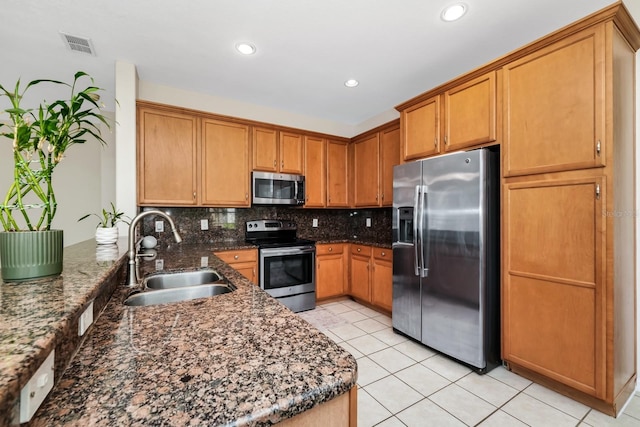 13520 Meadow Bay Loop, Orlando, FL 32824 - kitchen featuring stainless steel appliances, light tile patterned floors, tasteful backsplash, dark stone counters, and brown cabinets