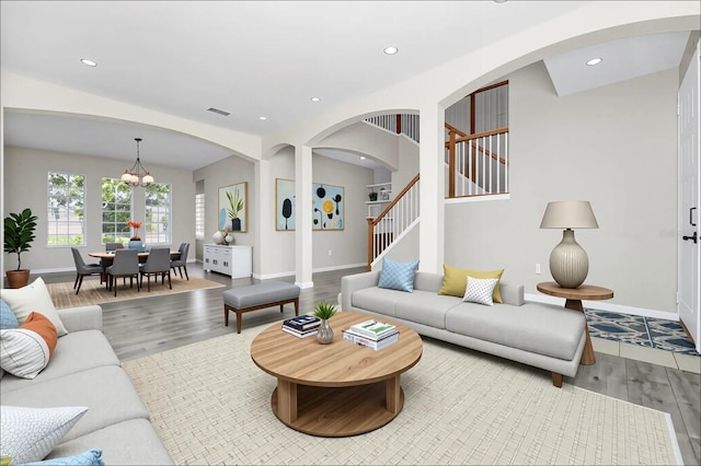 13520 Meadow Bay Loop, Orlando, FL 32824 - living area with wood finished floors, recessed lighting, stairway, a chandelier, and arched walkways