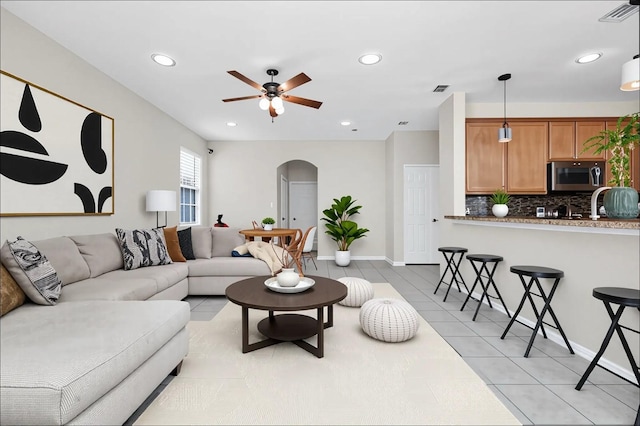 13520 Meadow Bay Loop, Orlando, FL 32824 - living area featuring arched walkways, ceiling fan, recessed lighting, and light tile patterned floors