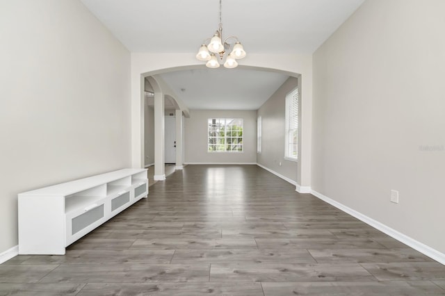 13520 Meadow Bay Loop, Orlando, FL 32824 - unfurnished room with arched walkways, a chandelier, and wood finished floors