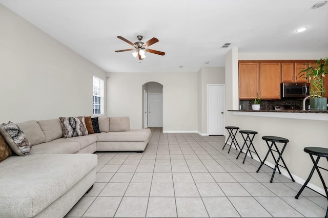 13520 Meadow Bay Loop, Orlando, FL 32824 - living area with arched walkways, a ceiling fan, and light tile patterned floors