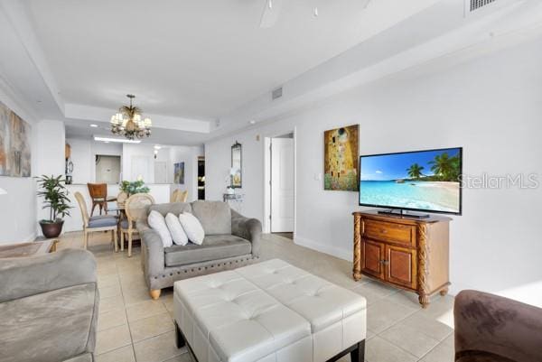 13427 Blue Heron Beach Dr Unit 1205, Orlando, FL 32821 - living area featuring a tray ceiling, visible vents, an inviting chandelier, and light tile patterned floors