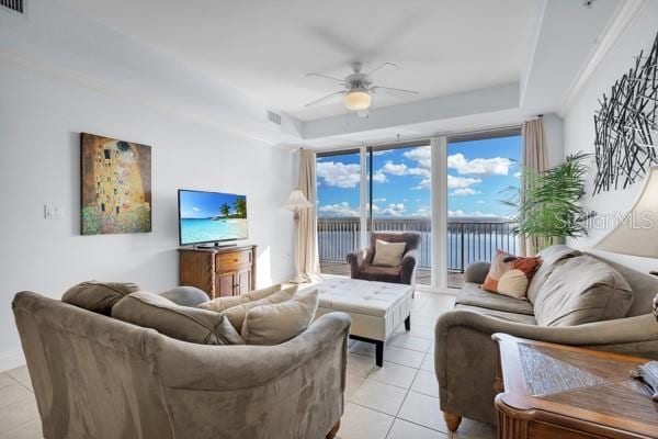 13427 Blue Heron Beach Dr Unit 1205, Orlando, FL 32821 - living area with a tray ceiling, visible vents, ceiling fan, and light tile patterned floors