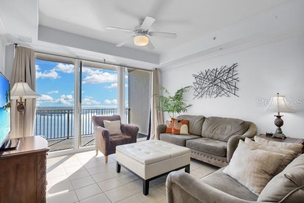 13427 Blue Heron Beach Dr Unit 1205, Orlando, FL 32821 - living room with a water view, light tile patterned floors, and a ceiling fan