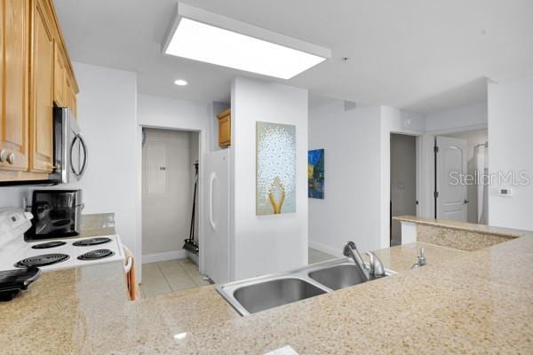 13427 Blue Heron Beach Dr Unit 1205, Orlando, FL 32821 - kitchen featuring recessed lighting, white appliances, light tile patterned floors, a sink, and light stone counters