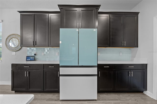 12048 Imaginary Way, Orlando, FL 32832 - kitchen with light wood-type flooring, decorative backsplash, light countertops, and freestanding refrigerator