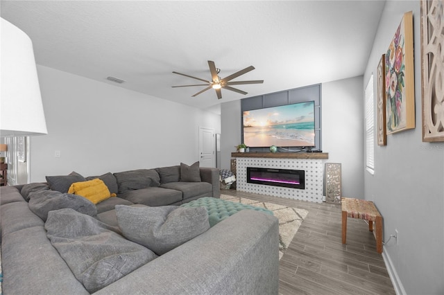 12048 Imaginary Way, Orlando, FL 32832 - living room featuring a ceiling fan, wood finished floors, a fireplace, baseboards, and visible vents