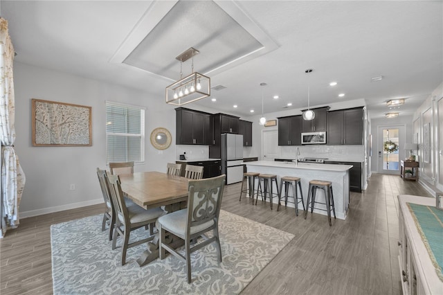12048 Imaginary Way, Orlando, FL 32832 - dining space featuring recessed lighting, a raised ceiling, light wood-type flooring, and baseboards