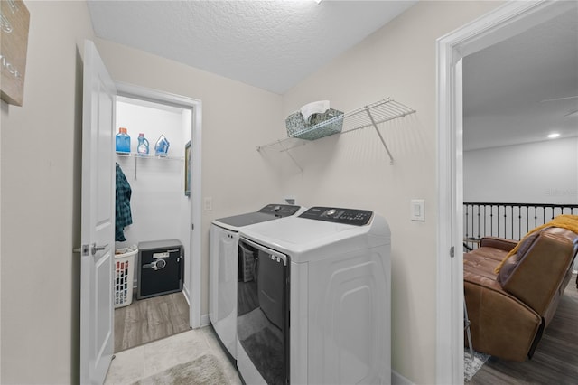12048 Imaginary Way, Orlando, FL 32832 - laundry room with washer and dryer, light wood finished floors, a textured ceiling, and laundry area