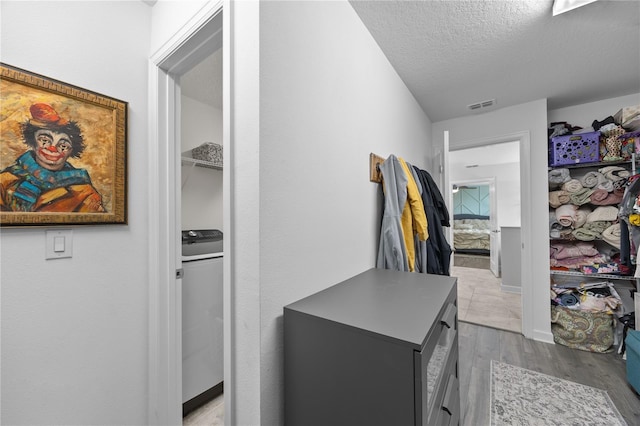 12048 Imaginary Way, Orlando, FL 32832 - hall featuring a textured ceiling, wood finished floors, visible vents, and baseboards