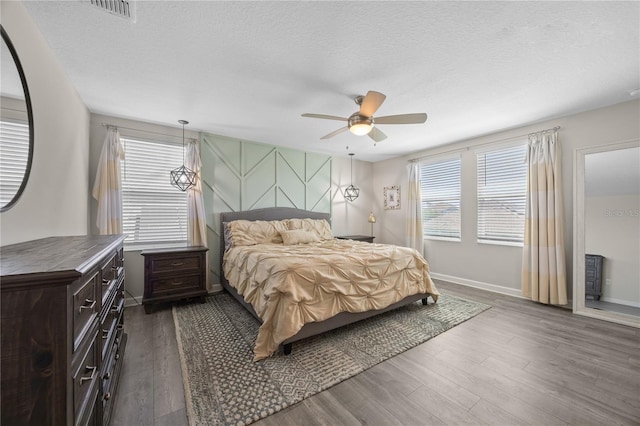 12048 Imaginary Way, Orlando, FL 32832 - bedroom featuring a textured ceiling, ceiling fan, visible vents, baseboards, and dark wood-style floors