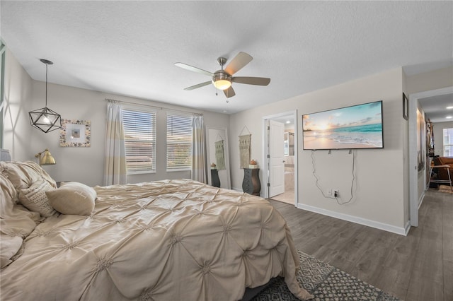 12048 Imaginary Way, Orlando, FL 32832 - bedroom with baseboards, wood finished floors, a textured ceiling, and connected bathroom