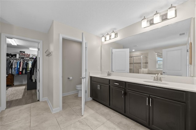 12048 Imaginary Way, Orlando, FL 32832 - bathroom featuring toilet, a sink, double vanity, and a stall shower