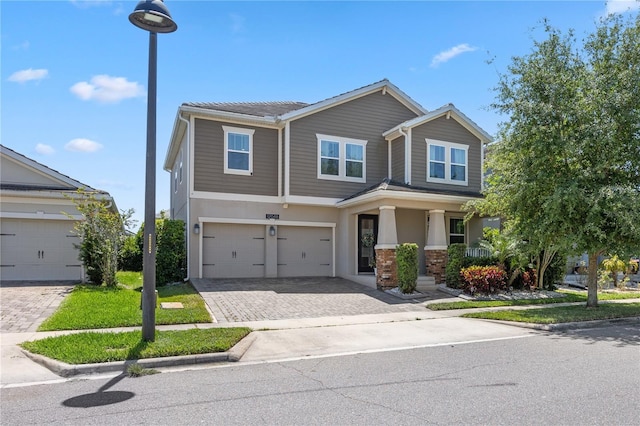 12048 Imaginary Way, Orlando, FL 32832 - craftsman inspired home with a tile roof, a porch, a garage, stucco siding, and decorative driveway