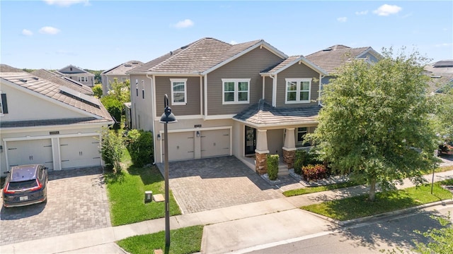 12048 Imaginary Way, Orlando, FL 32832 - craftsman-style home featuring decorative driveway, a tiled roof, a porch, stucco siding, and a residential view