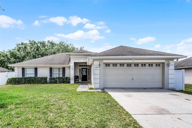 view of front of house with a front lawn, driveway, stucco siding, and a garage