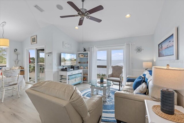 living area with lofted ceiling, a ceiling fan, visible vents, and light wood-type flooring