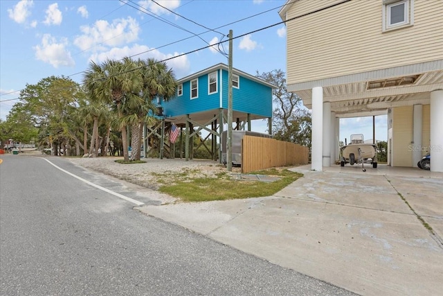 view of side of property with driveway, fence, and a carport