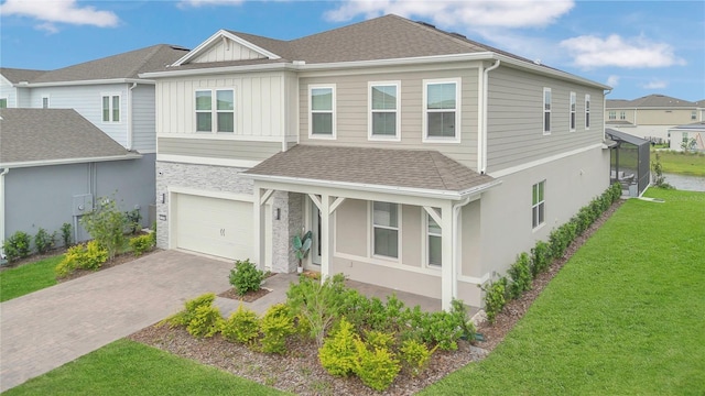 13640 Haulover Beach Ln, Orlando, FL 32827 - view of front of home featuring an attached garage, a shingled roof, decorative driveway, and a front lawn