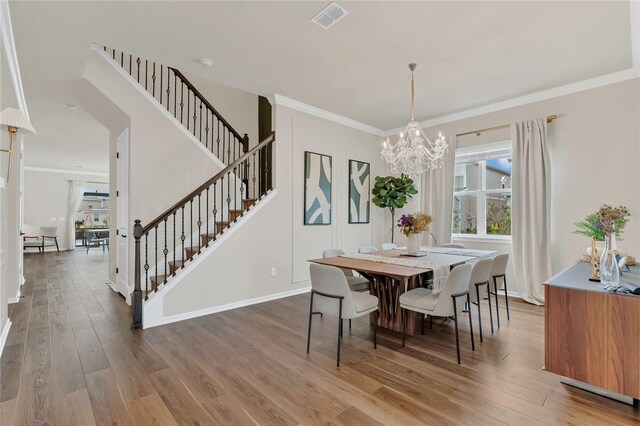 13640 Haulover Beach Ln, Orlando, FL 32827 - dining area featuring a chandelier, wood finished floors, visible vents, and stairway