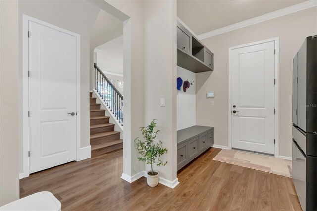 13640 Haulover Beach Ln, Orlando, FL 32827 - mudroom featuring crown molding, baseboards, and light wood finished floors