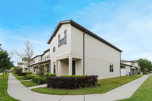 view of property exterior featuring central air condition unit, stucco siding, and a yard