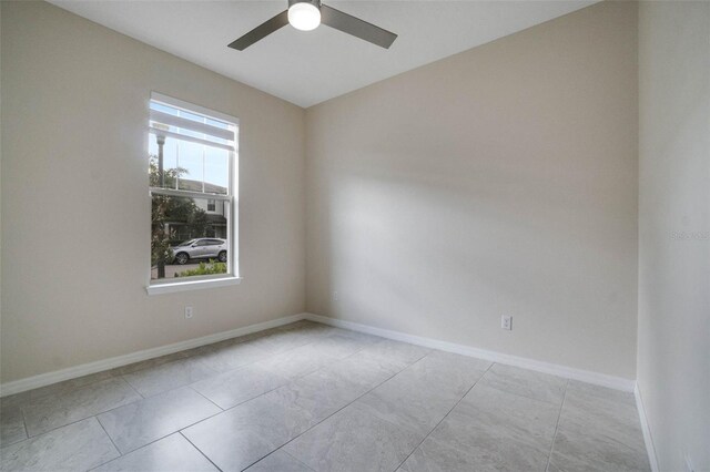 empty room featuring baseboards and a ceiling fan