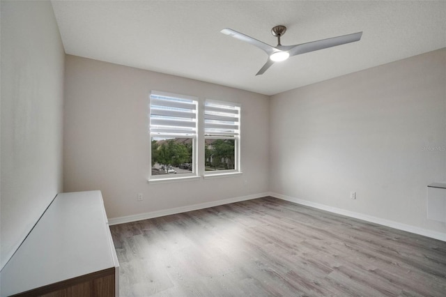 unfurnished room with baseboards, wood finished floors, and ceiling fan